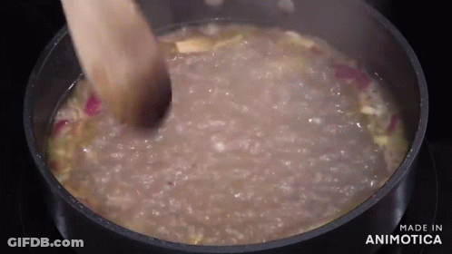 Person Stirring Pot Of Soup With Wooden Spoon GIF