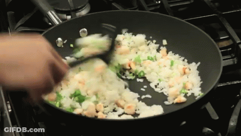 Person Stirring Rice And Shrimp In Frying Pan GIF