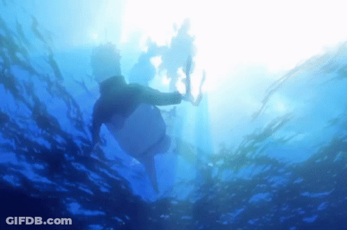 Person Swimming In Ocean With Sun Shining Through GIF