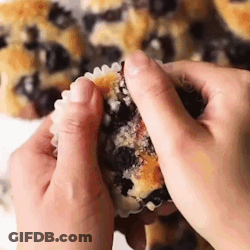 Person Taking A Bite Of Blueberry Muffin GIF