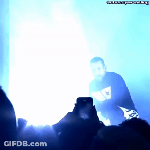 Person Taking Photo Of Man In Blue Wrestling Shirt GIF