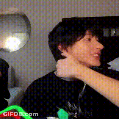 Person Touching Another's Ear While Sitting GIF
