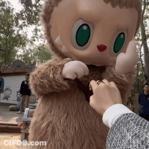 Person Touching Stuffed Animal With Green Eyes GIF