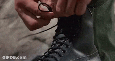 Person Tying Boots On Sidewalk GIF