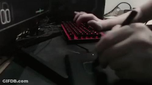 Person Typing On Keyboard In Front Of Dual Settings Monitor GIF