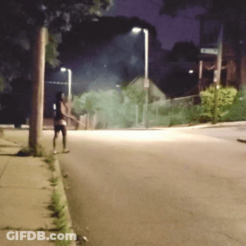 Person Walking Down Street At Night With Emerson Sign GIF