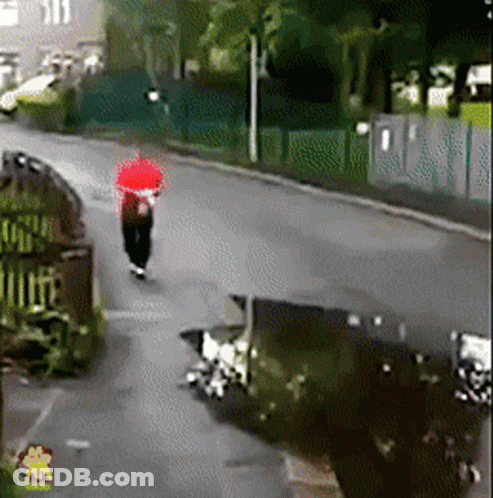 Person Walking Down Street With Red Umbrella GIF