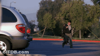 Person Walking In Parking Lot With Silver Minivan GIF