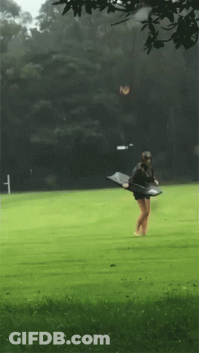 Person Walking On Green Field With Skateboard GIF