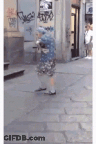Person Walking Past Graffiti Building GIF