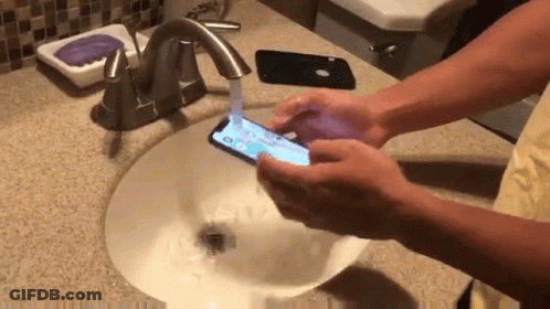 Person Washing Hands While Holding Phone GIF