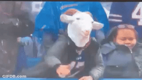 Person Wearing Goat Mask Sitting In Stadium With Child GIF