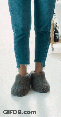 Person Wearing Grey Slippers With Evian Bottle GIF