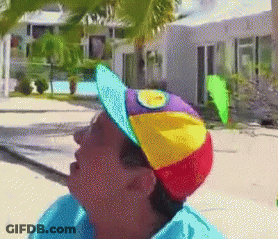 Person Wearing Rainbow Hat With Yellow Sun GIF