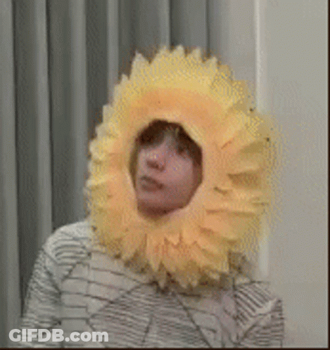 Person Wearing Yellow Sunflower Hat GIF