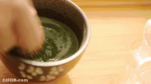 Person Whisking Bowl Of Green Liquid With Brush GIF