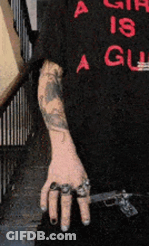 Person With Arm Tattoo Holding Gun GIF