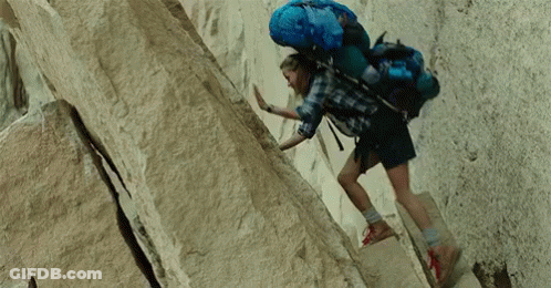 Person With Blue Backpack Climbing Rock Wall GIF