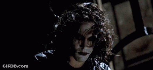 Person With Curly Hair In Dark Room Wearing Black Jacket GIF