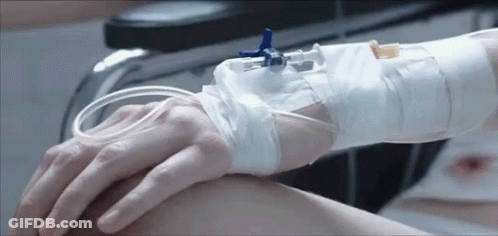 Person With IV Holding Hand In Hospital Bed GIF