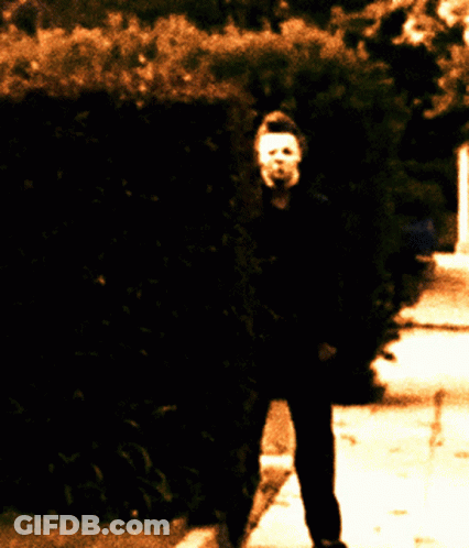 Person With Mask Walking Down Sidewalk GIF