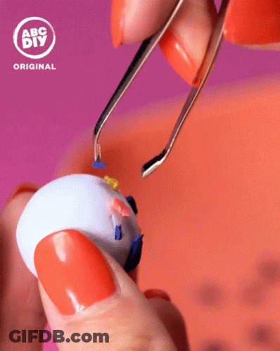 Person With Orange Nails Holding Toy GIF
