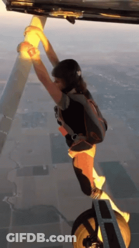 Person With Parachute Hanging From Plane GIF