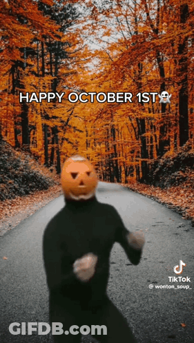 Person With Pumpkin Head Dancing On Autumn Road GIF