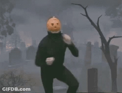 Person With Pumpkin On Head Dancing In Cemetery GIF