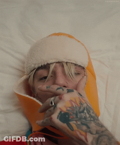 Person With Tattoo Covering Mouth With Hand GIF