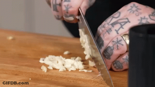 Person With Tattooed Fingers Chopping Garlic GIF