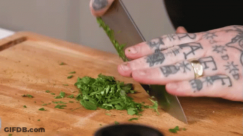 Person With Tattoos Cutting Greens GIF