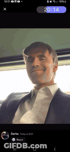 Phone Screen Showing Man In Suit And Tie At 20:14 GIF