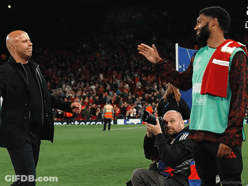 Photographer Taking Picture Of Two Men Shaking Hands On Field GIF