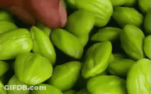 Pile Of Green Beans With Red Object GIF