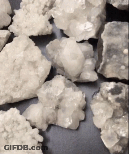 Pile Of White Rocks On Black Background GIF