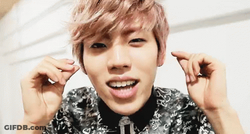 Pink-Haired Man Making Heart Shape And Smiling GIF