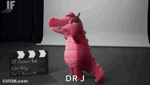 Pink Stuffed Alligator In Front Of Clapper Board GIF