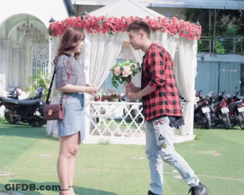 Plaid Shirt Man Holding Bouquet To Woman GIF