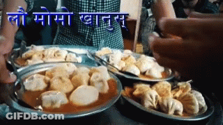 Plates Of Food With Sign Saying Lo Momo GIF
