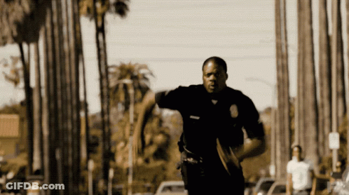 Police Officer Running Down Street With Palm Trees GIF