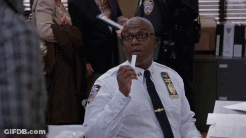 Police Officer Sitting At Desk Holding Paper GIF