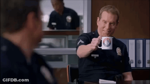 Police Officer Sitting At Desk Holding Police Department Mug GIF