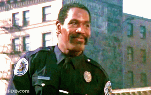 Police Officer Standing In Front Of Building GIF