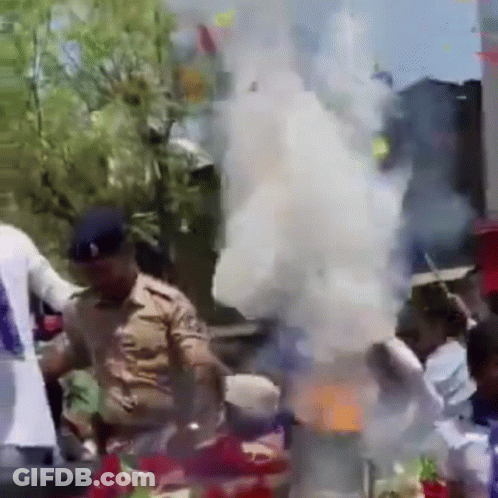 Police Officer Standing In Front Of Crowd With Smoke GIF