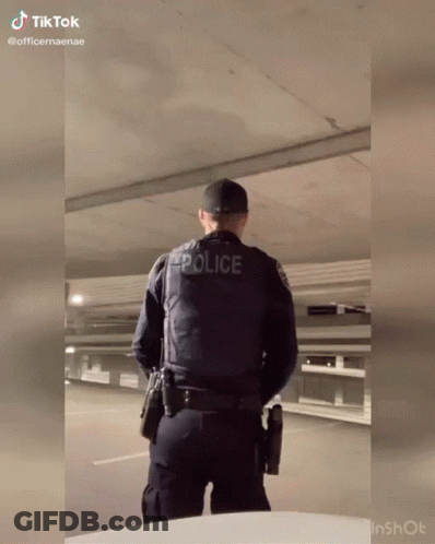 Police Officer With Gun In Parking Garage GIF