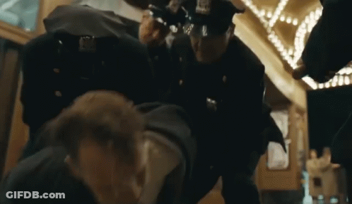 Police Officers Standing Around Man GIF