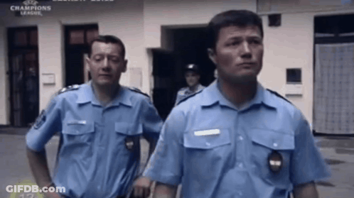 Police Officers Standing In Front Of Champions League Building GIF