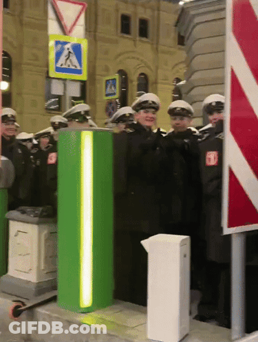 Police Officers Standing Next To Green Pole GIF