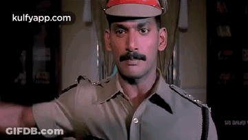 Policeman In Red Hat And Mustache Standing In Room GIF